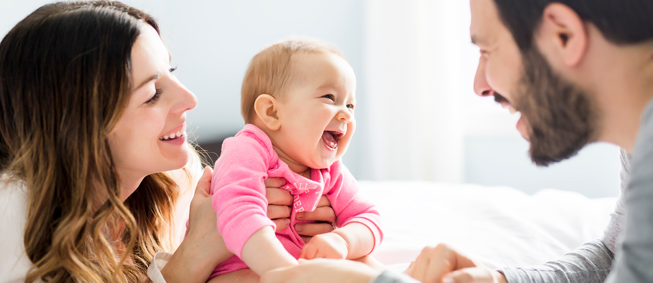 Female holding smiling infant after completing her perinatal mental health course 